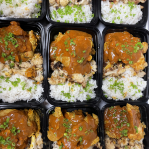 black takeout containers filled with meat, rice and sauce